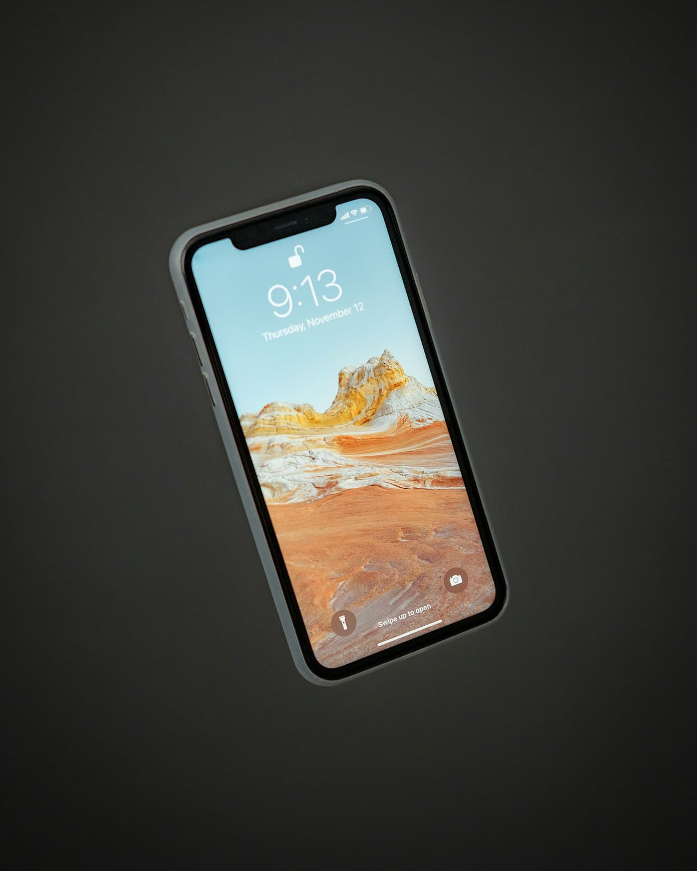 Smartphone with a lit screen on a dark surface
